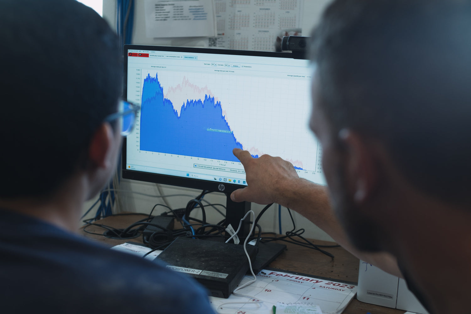 Two barn workers in front of a computer looking a VISION software